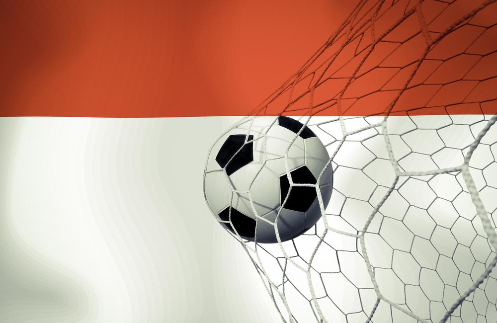 Spiele beim AS Monaco Der Fußball ist vor einer monegassischen Fahne im Netz